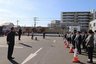 市役所駐車場で訓練のために整列して話を聞いている職員の人達の写真