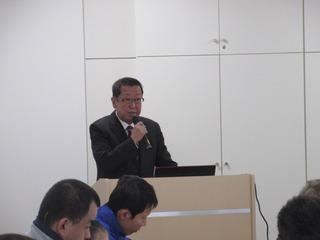 市長が演台でマイクを持って話をしている写真