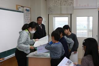 教壇にいる先生のところへ集まっている男子生徒達の様子を後ろから見ている市長の写真