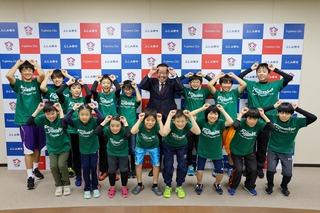 緑のユニフォーム姿のスポーツ鬼ごっこに出場した皆さんが頭に手をのせ角に似せてポーズをとり市長と一緒に撮影した写真