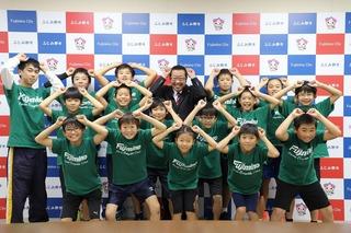 緑色のユニフォームを着たふじみ野市スポーツ鬼ごっこ連盟の皆さんが、両手にこぶしを作って頭の上に乗せたポーズを市長も一緒に全員で決めて、元気よく笑顔で写っている写真