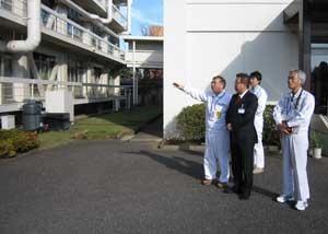 株式会社日清製粉グループ本社の屋外から、職員の方が市長に指を指しながら説明をしている写真