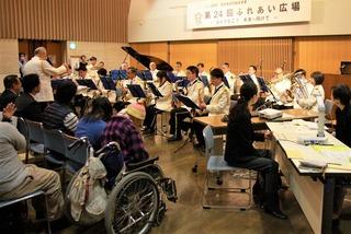 車いすやたくさんの人達の前で演奏をしている人達の写真