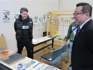いろいろな作品をみている市長と男性の写真