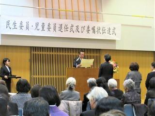 舞台で賞状を読み上げる市長と関係者の人達の写真