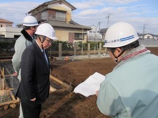 ヘルメット姿で作業の人の説明を聞いている市長の写真