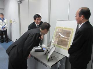 展示されているものを身を乗り出しながらみている市長とその横で説明をしている関係者の人の写真