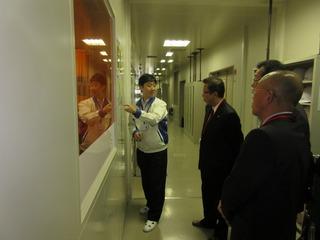 うす暗い廊下のような場所のガラス張りの中の展示物の説明を聞いている市長達の写真