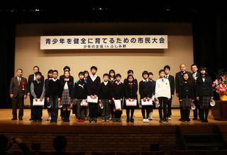 青少年を健全に育てるための市民大会で、舞台上に並ぶ関係者や、参加者の学生の集合写真