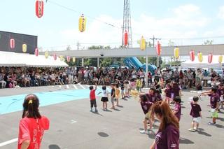 小さな子供たちが並んでダンスの発表をしている様子を遠くからうつした写真