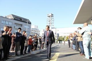 市民の皆様の拍手を受けながら登庁している市長の写真