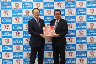 知育玩具を持ってオリエントコーポレーション代表の方と市長が記念撮影をしている写真
