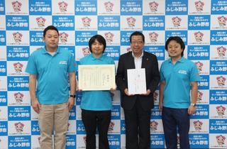 ふじみ野市商工会青年部の皆さん3名のうちの中央の女性が賞状を手に持って、市長が募金を手に持ち、4名で写っている写真