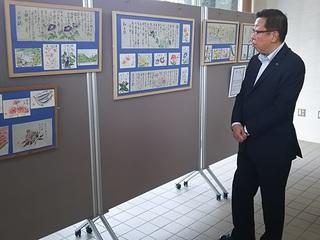 紫色の朝顔の描かれている絵手紙などが展示されており、市長が作品の前で見入っている写真