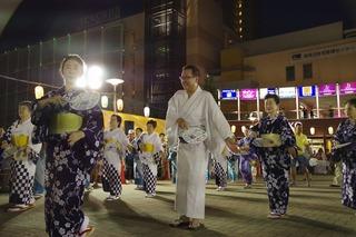 浴衣を着た女性たちと一緒に盆踊りを踊っている市長の写真