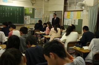 子ども達は席に着いて授業を受けており、市長がその様子を前方の入り口付近で見ている写真