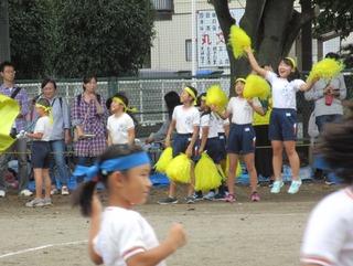 黄色いボンボンを持って応援をしている児童たちの写真