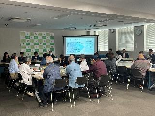 前方に座る議員から議会で審議した内容の報告を受ける参加者の写真
