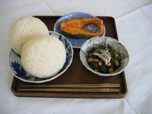 給食の始まりのメニューを再現したおにぎり2つ・焼き魚・漬け物の献立の写真