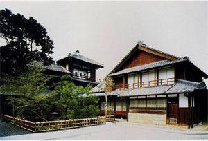 明治時代に立てられた、家の前に植木がある木造2階建て旧船問屋福田屋の主屋の写真