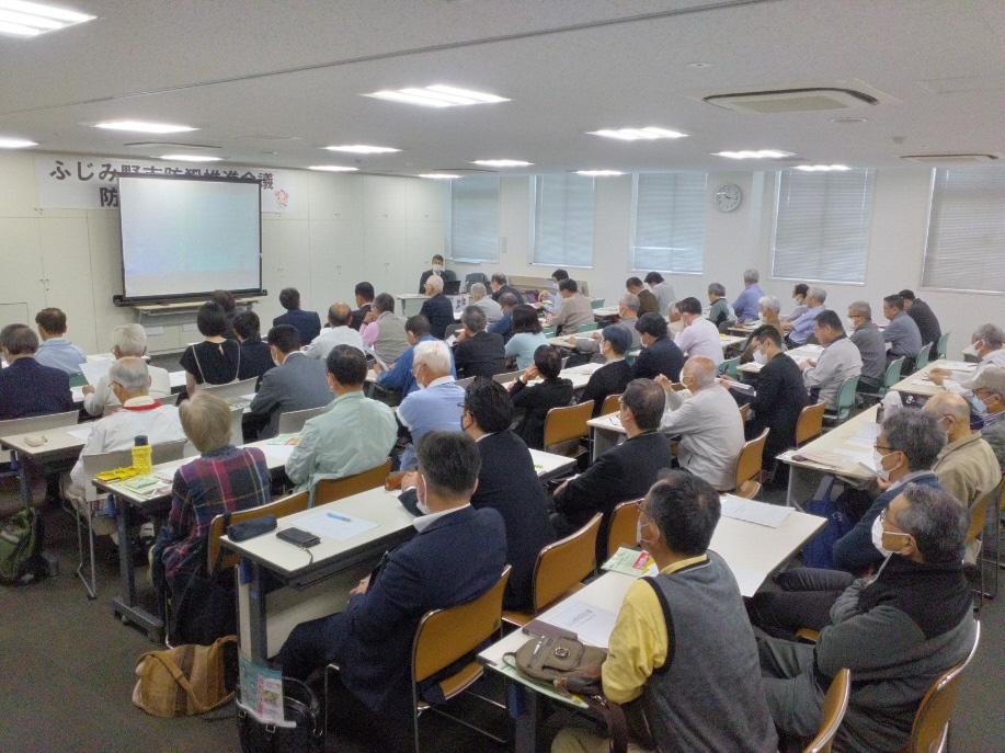 スクリーンに資料を投影し、講師が参加者に向けて説明している写真