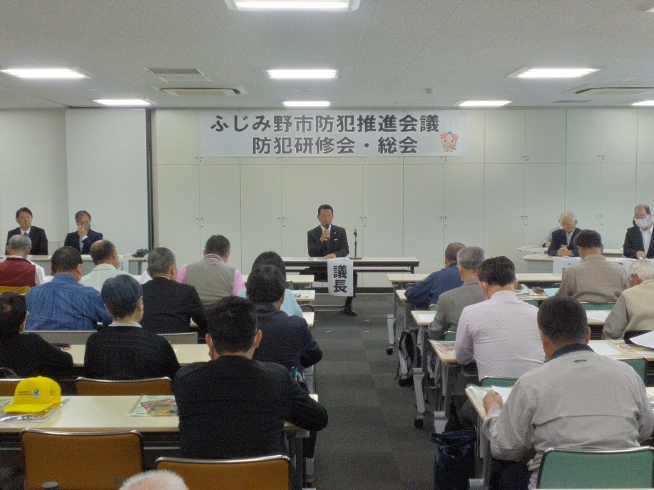 総会出席者を前に、議長が議事を進行している様子の写真
