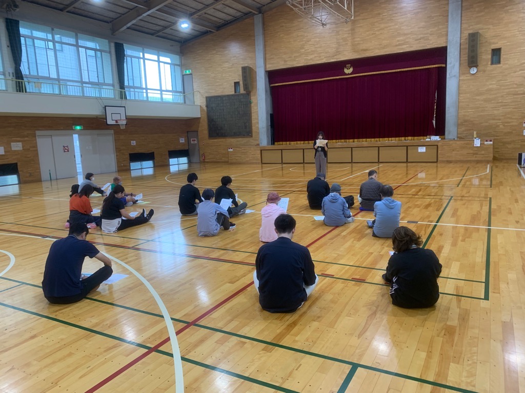 体育館で講師が受講者に運動をより効果的にする食事について説明している写真
