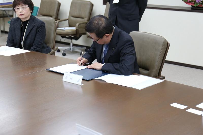 調印書にサインをしている市長の写真