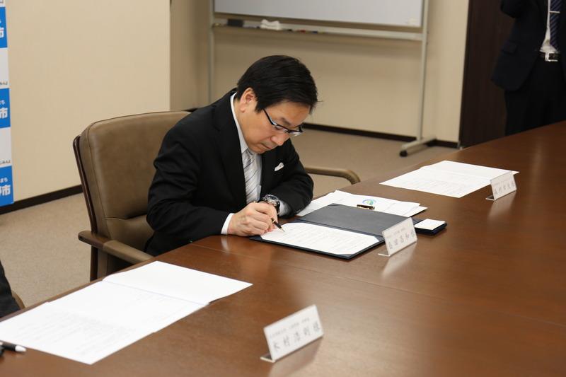 法人文京学園の代表の方が協定書に調印をしている写真