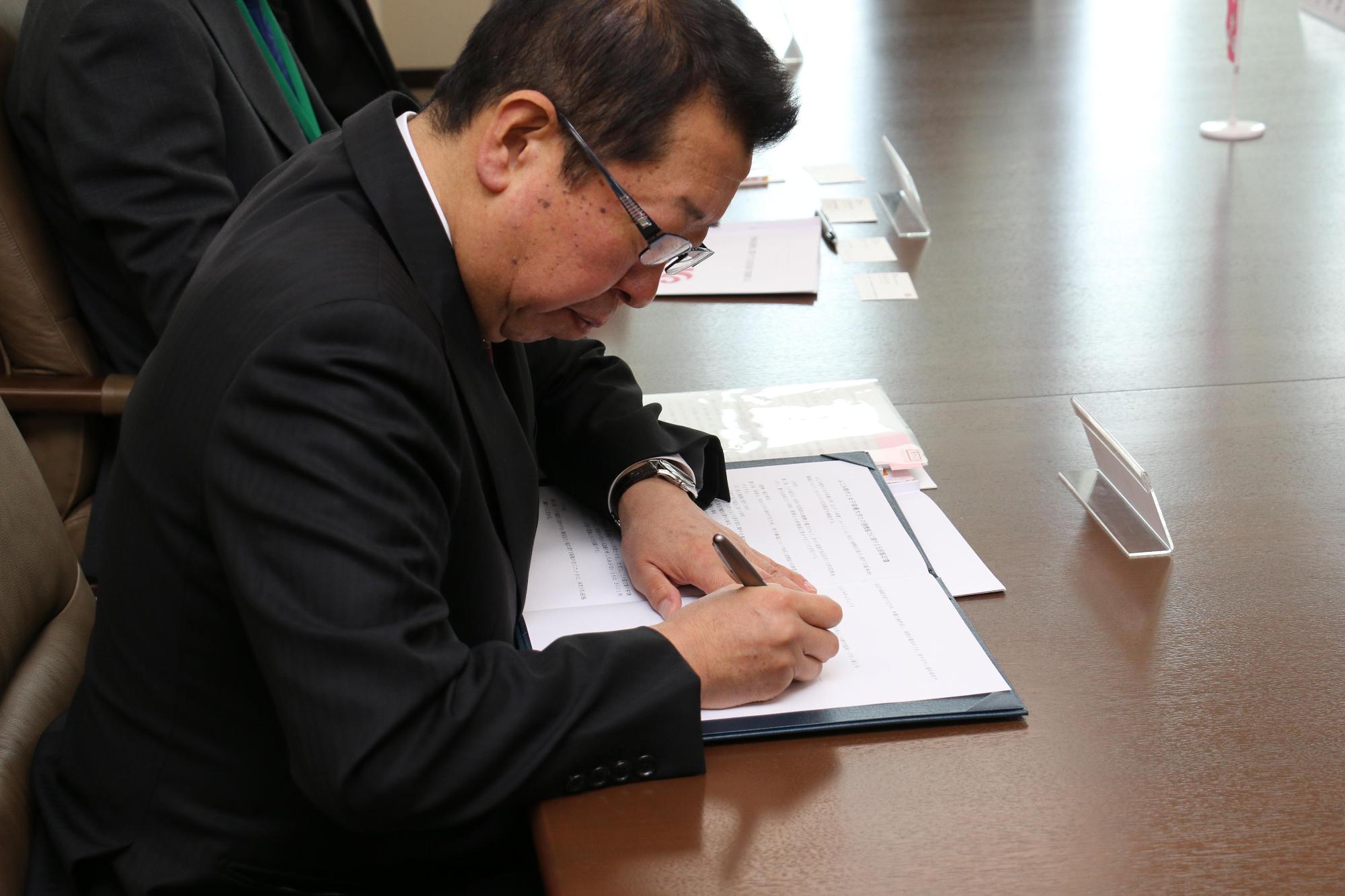 協定書に調印をしている市長の写真
