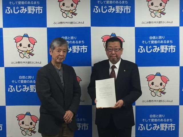 市長が答申書を手に持って会長の伊藤様と一緒に写っている写真