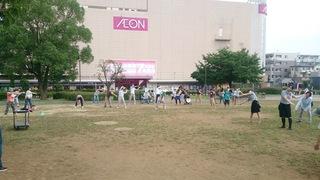 イオン大井店の広場に地域の方が集まって、両手を回して腰の運動をしているラジオ体操の写真