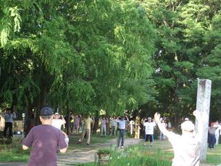 東原親水公園に、地域の方が集まって、両手を上に挙げてラジオ体操をしている写真