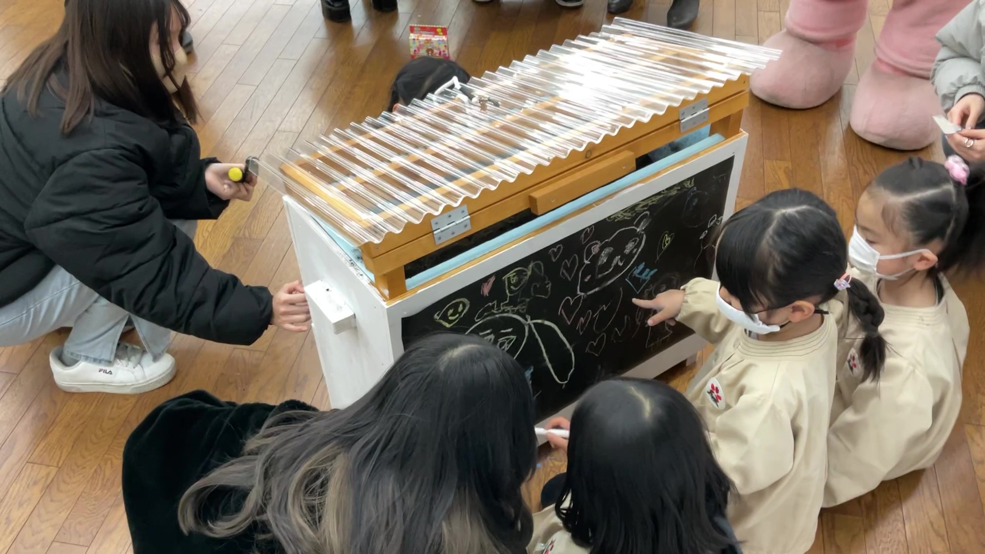 文京学院大学の学生が文京学院幼稚園の園児とともにキエーロに絵を描いている写真