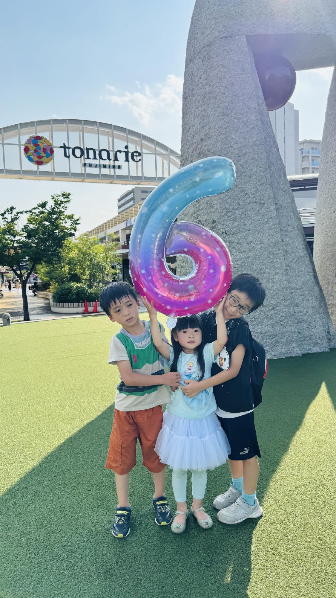 トナリエで2人の男の子と1人の女の子の兄妹が6の数字バルーンを持っている写真