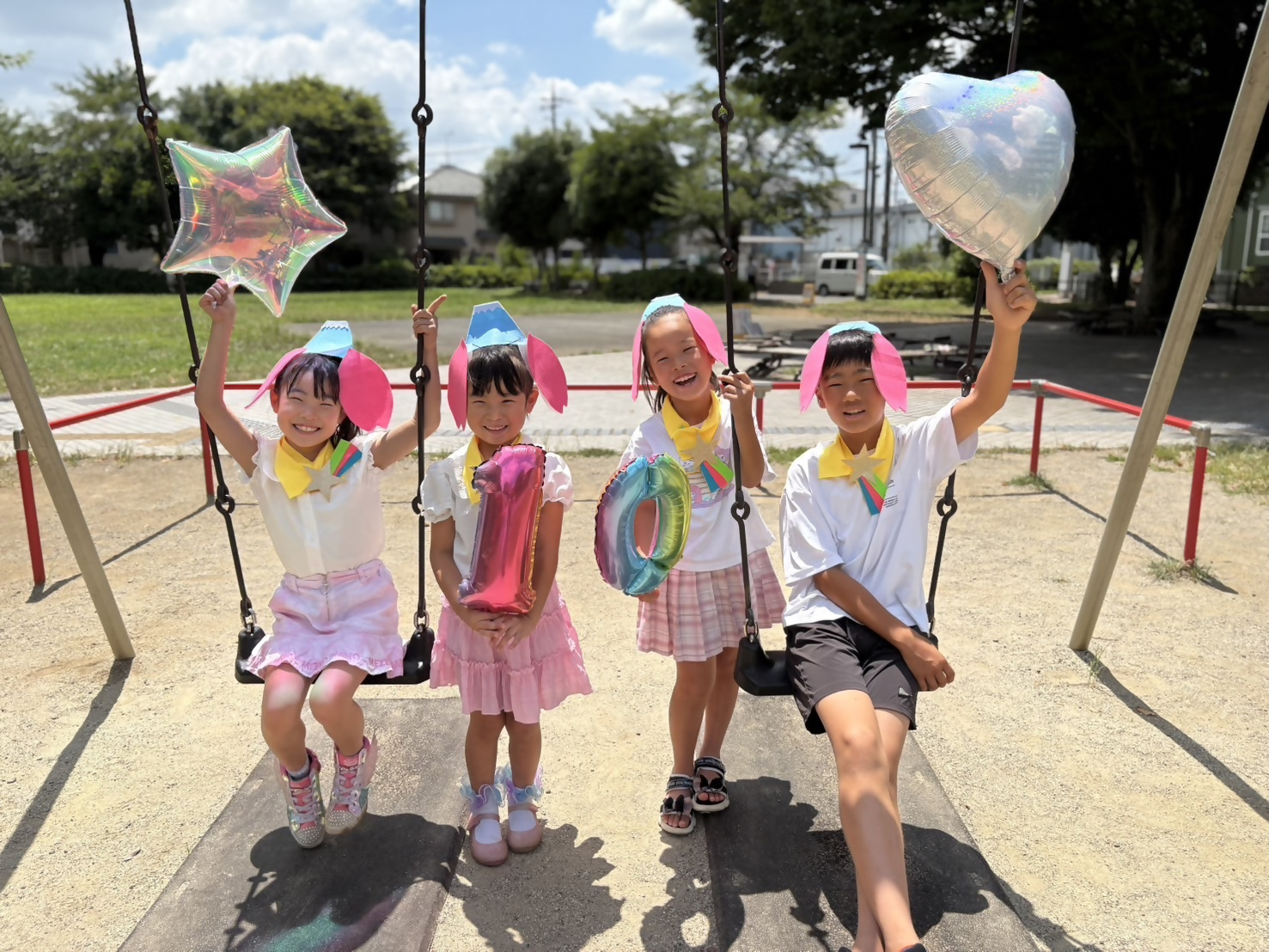 亀久保中央公園のブランコで女の子4人が集まって10の数字バルーンと星のバルーンを持っている写真