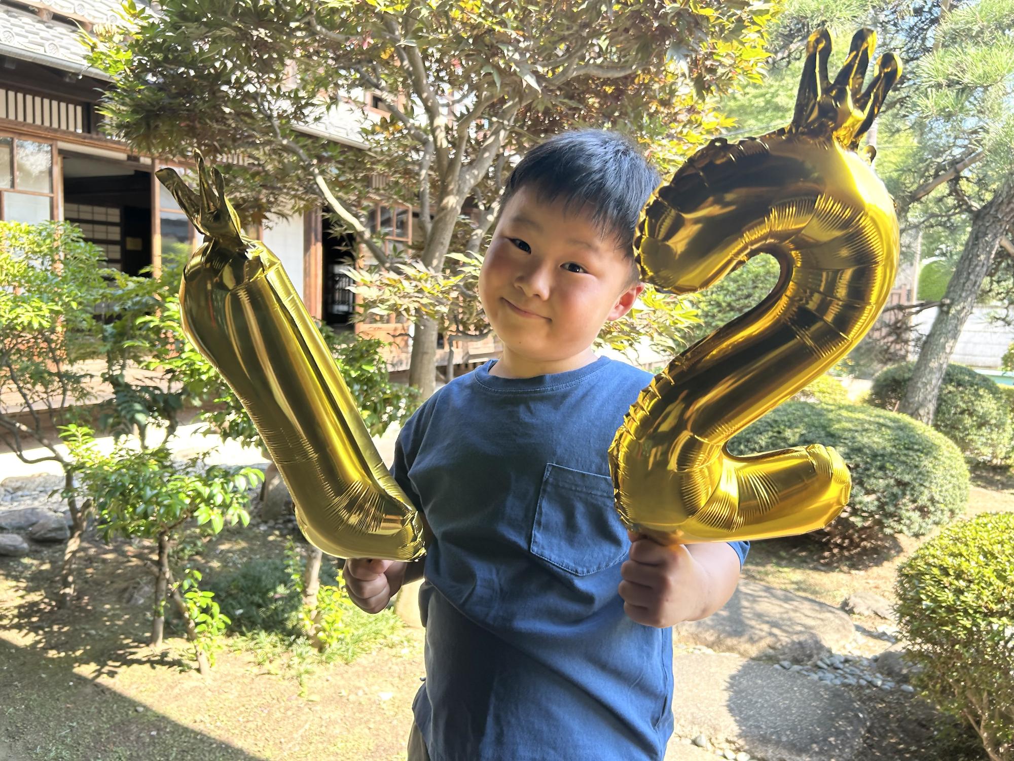12のバルーンナンバーを持った少年の写真