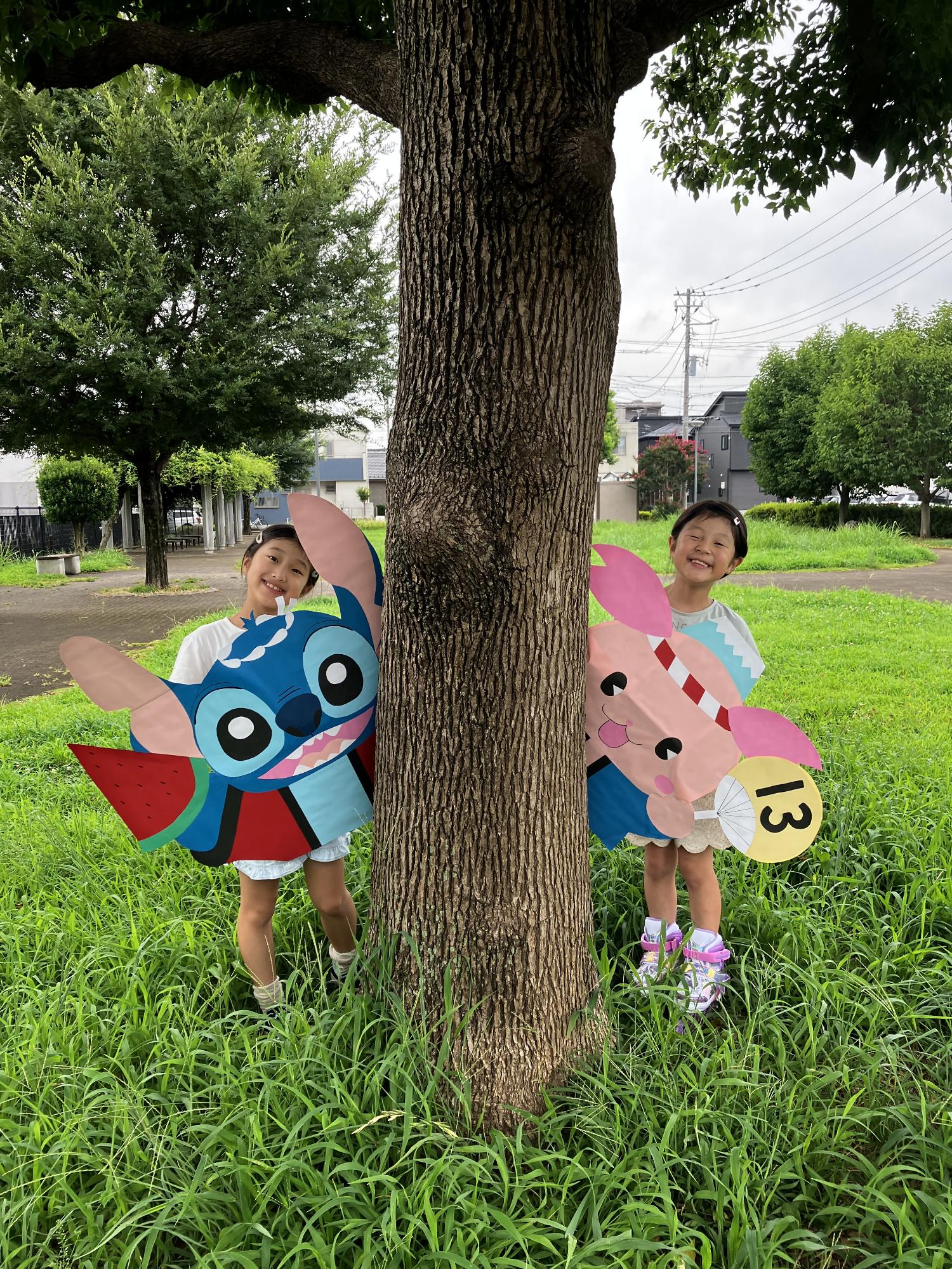 2人の女の子がスティッチとふじみんの手作り看板を持っている写真