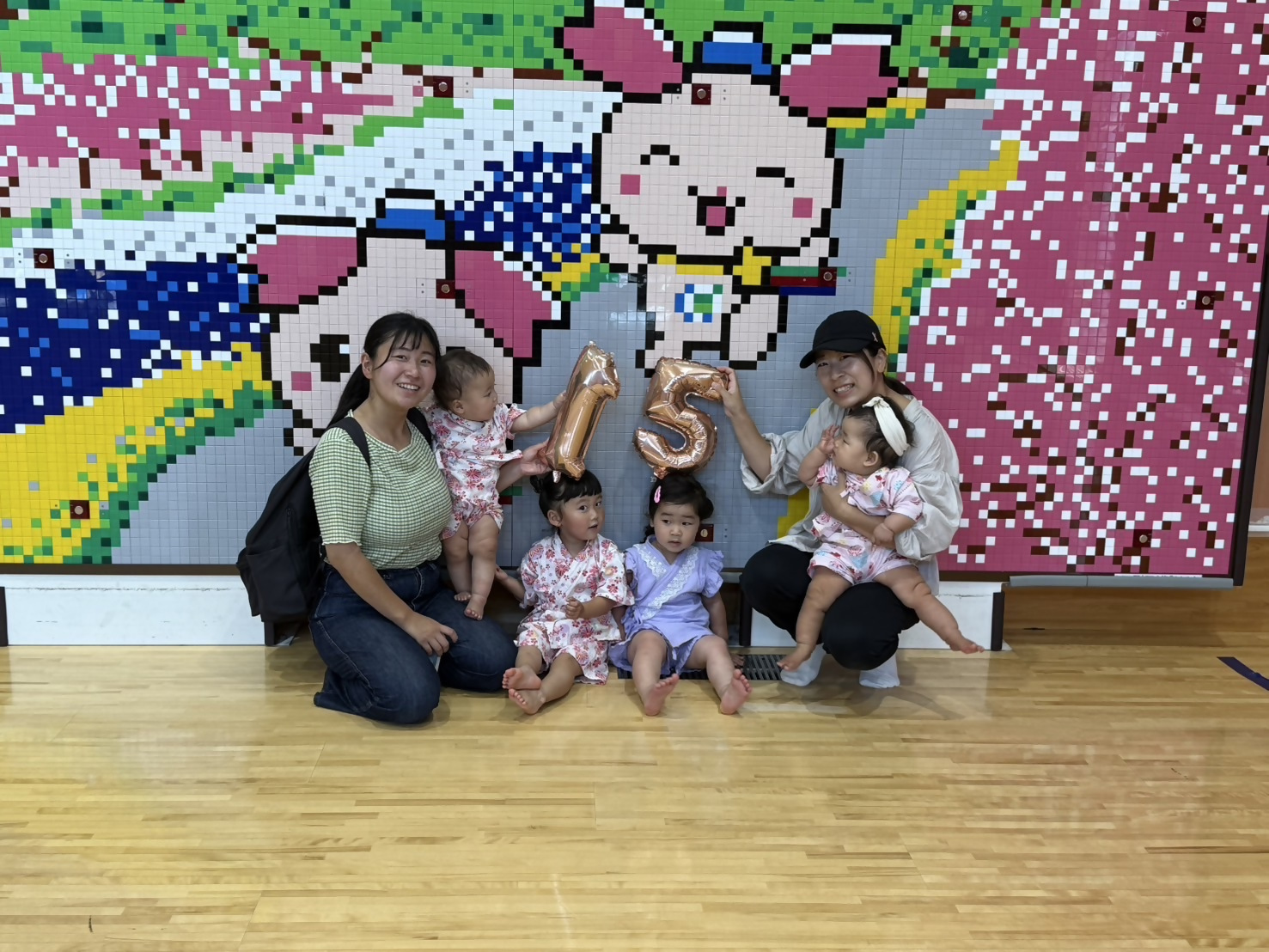 2人の母親とその子供たちが15の風船を持っている様子