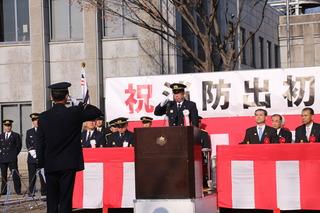 消防出初式で市長と消防隊員の方が向き合って敬礼をしている写真