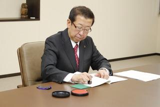 協定書に押印する市長の写真