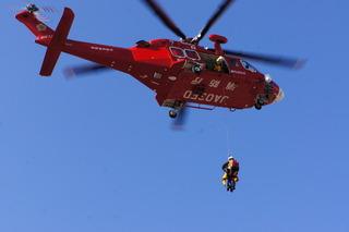 ヘリコプターからロープをつるして救助訓練をしている写真