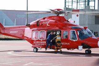 赤いヘリコプターに人を乗せる訓練をしている写真