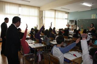 亀久保小学校にて授業中に生徒が手を上げている様子を見学する市長の写真