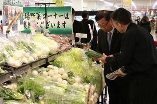 イオン大井店の野菜コーナーで男性スタッフより説明を受ける市長の写真