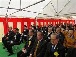 紅白の横断幕が巻かれているテントの中に、沢山の関係者の方が安全祈願祭りに出席され、パイプ椅子に座っている写真