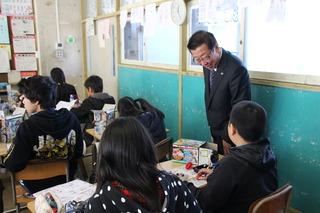 福岡小学校にて廊下側の通路で授業を見学している市長の写真
