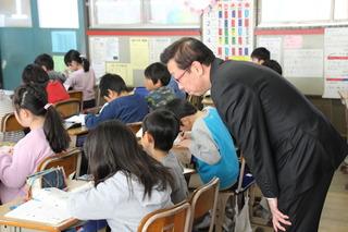 駒西小学校にて授業を受けている生徒を後ろから見学している市長の写真