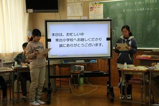 東台小学校にて教室の電子黒板の前で発表する生徒たちの写真