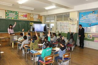 西原小学校にて授業中に生徒が手を上げている様子を見学する市長の写真